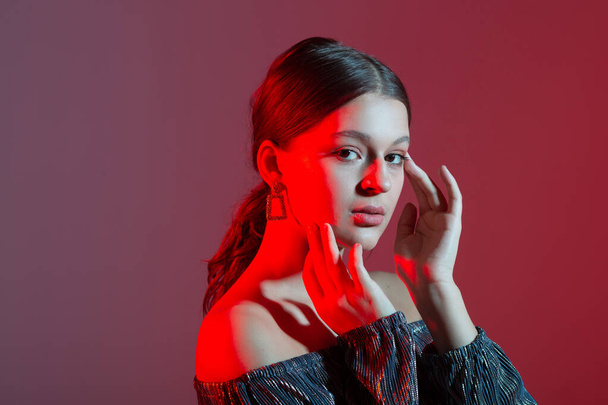 portrait of a beautiful young woman with colored lighting - Fotografie, Obrázek