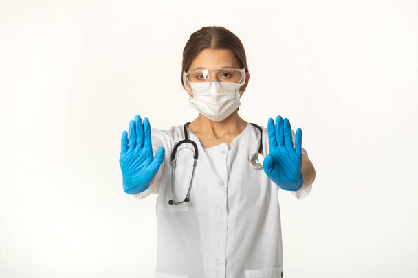 young woman in medical uniform on white background with hand gesture - Foto, imagen
