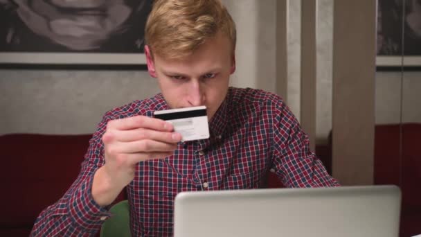 Молодой кавказский человек с помощью ноутбука Оплата онлайн покупок кредитной картой. Услуги электронного банкинга и электронной коммерции.  - Кадры, видео
