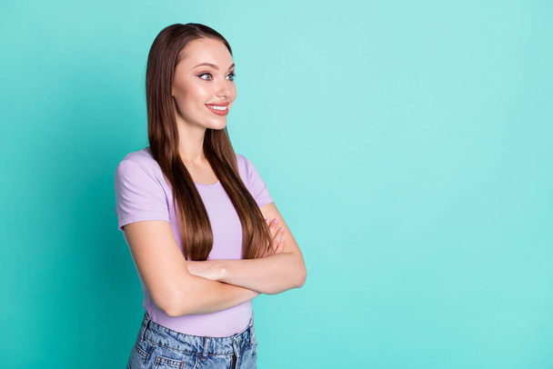 Side profile photo of smiling girl with crossed hands looking at empty space isolated on vibrant teal color background - Fotó, kép