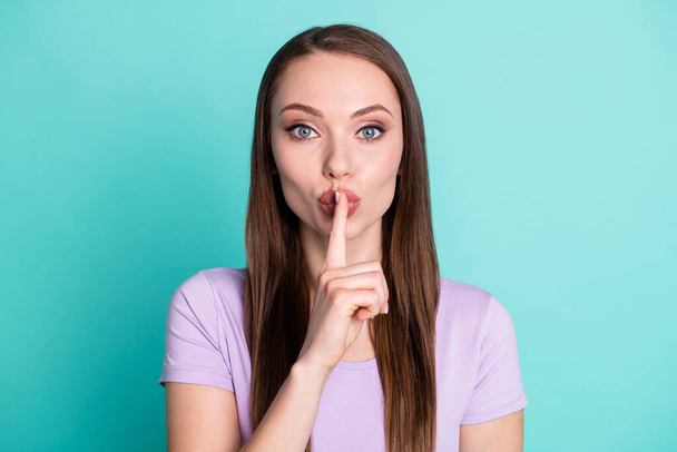 Photo portrait of pretty girl keeping secret touching lips with finger isolated on vivid teal color background - 写真・画像