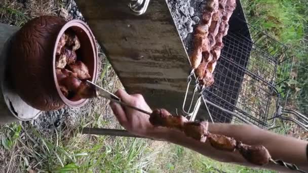 Vertikale Aufnahmen. Gegrillter Schweinebraten vom Spieß in Töpferschüssel - Filmmaterial, Video
