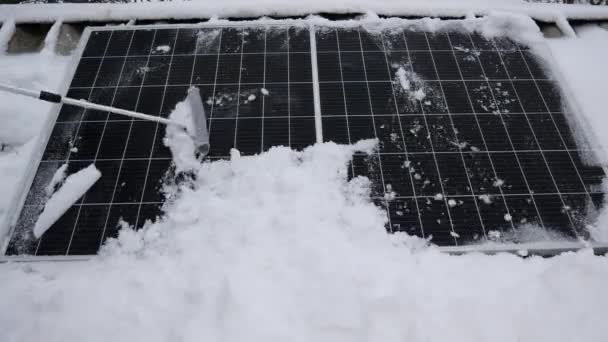 Removing snow from the solar panel. The solar element under the snow. Precipitation reduces the efficiency of energy production.  In winter, you need to clean the panels from snow - Footage, Video