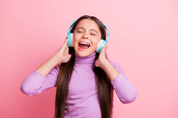 Photo of crazy kid girl enjoy listen music on wireless headset isolated over pastel color background - Фото, зображення