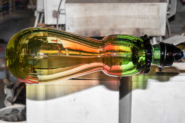 Eine heiße Glasmasse aus einem heißen Ofen in ein Kunstwerk verwandeln. Besichtigung der Glasfabrik. Die Glasherstellung hautnah - Foto, Bild
