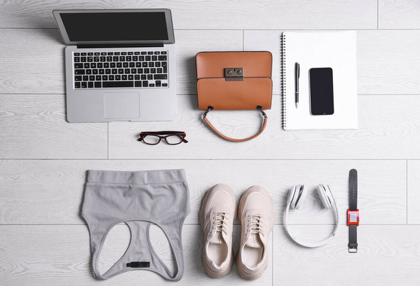 Flat lay composition with business supplies and sport equipment on white wooden floor. Concept of balance between work and life - Foto, Imagem