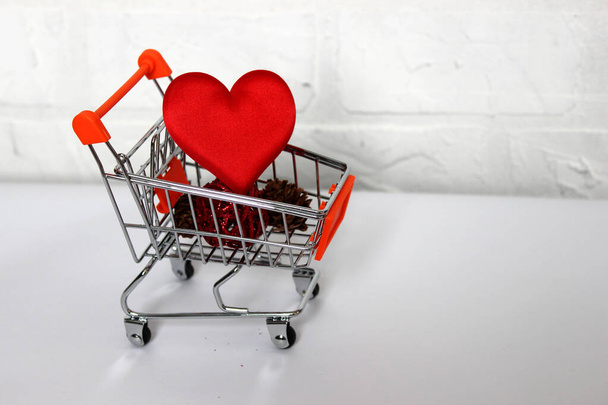 Red heart in shopping cart over white - Zdjęcie, obraz