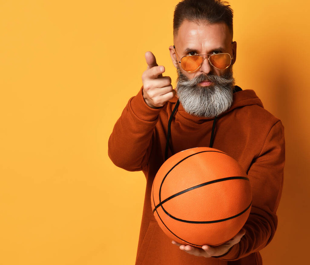 Bearded man offering to practice basketball game studio shot - Фото, зображення