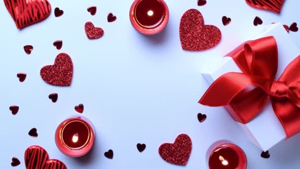 Liefde achtergrond: Valentijnsdag rode harten, romantische geschenkdoos, kaars op witte tafel. Romantische berichtsjabloon met kopieerruimte. Vlakke lay, bovenaanzicht, kopieerruimte - Video