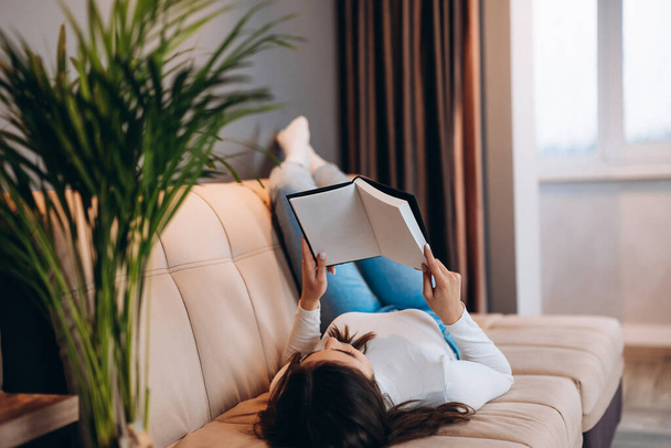 Menina bonita está lendo revista notebook em casa. Jovem estudante. Freelancer feminino interior - Foto, Imagem