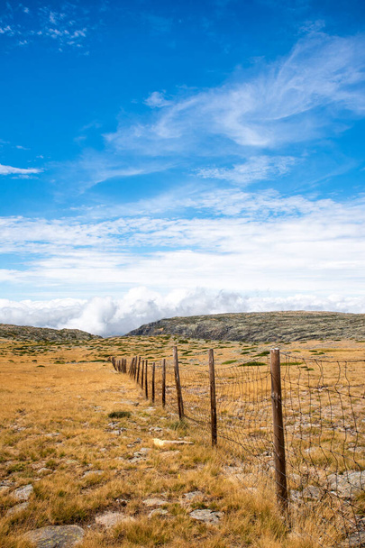 Wooden fence in the mountain towards the sky with clouds in the Serra da Estrela in Portugal - Fotoğraf, Görsel