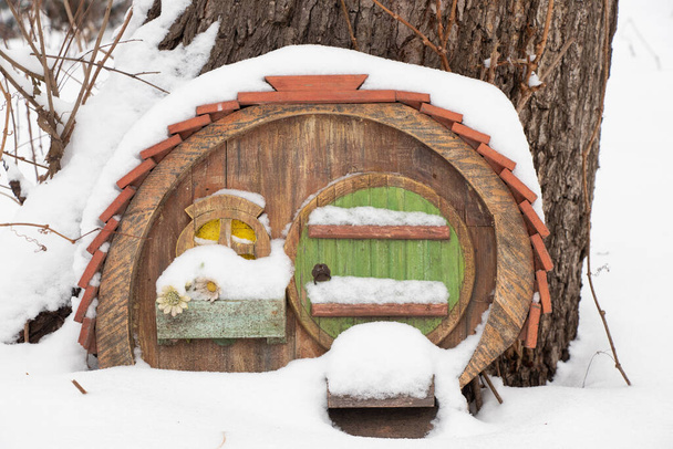 piccola casa di legno fiabesca in un albero in un parco in inverno sulla neve - Foto, immagini