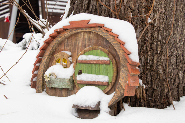 mały bajkowy drewniany dom na drzewie w parku zimą w śniegu - Zdjęcie, obraz
