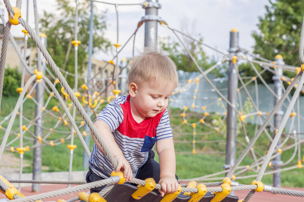 A little boy enthusiastically plays on the playground. Success, creative ideas and sports concepts. Children's playground. Games.  - Foto, Imagem