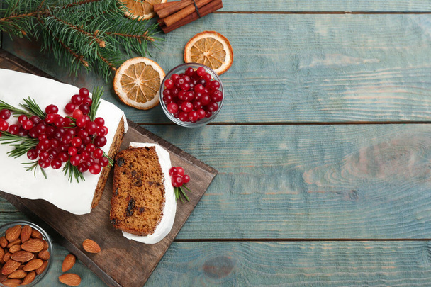 Traditional Christmas cake and ingredients on light blue wooden table, flat lay with space for text. Classic recipe - Foto, Imagen