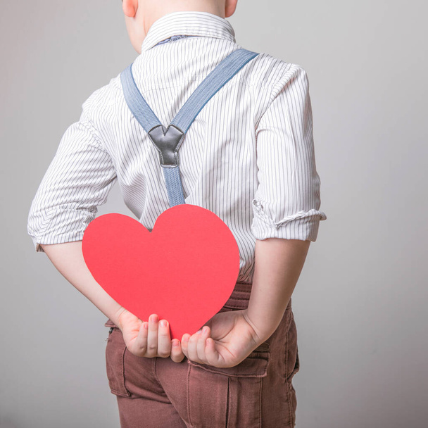 Boy holding a red heart  - Fotó, kép