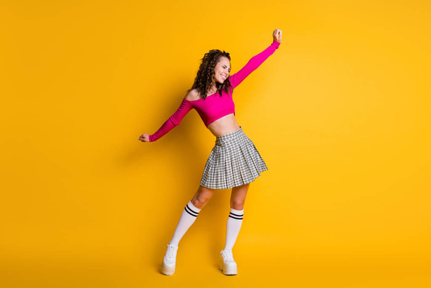 Full length photo of attractive charming crazy glad lucky wavy lady raise spread arms wear pink cropped top mini plaid skirt white socks shoes isolated yellow color background - Photo, Image