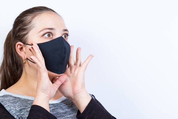 Young woman in black mask cry for help on a white background witrh copyspace. - Photo, Image
