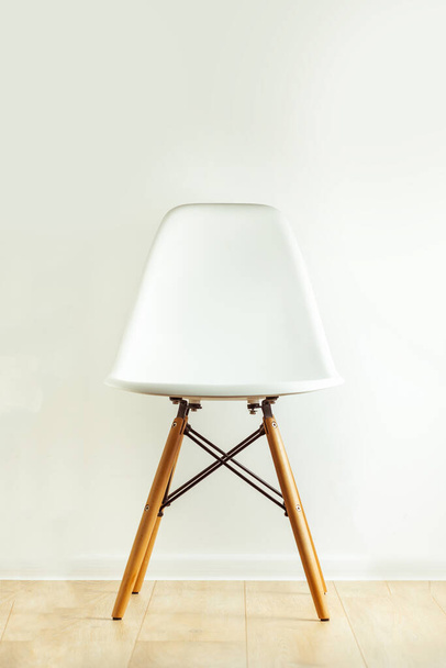 白い背景に木製の脚を持つモダンな椅子 - 写真・画像