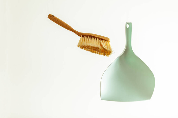 Wooden garbage brush and turquoise scoop levitate on a white background - Foto, Imagem