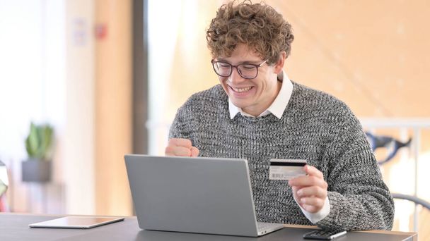 Online winkelen Succes op laptop door jonge man  - Foto, afbeelding