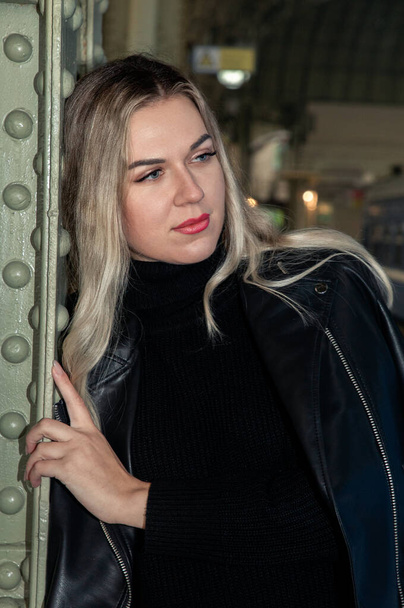 Portrait of Young beautiful woman in leather jacket posing on the train station peron. Waiting for the train Vitebsk station St. Petersburg. - Fotografie, Obrázek