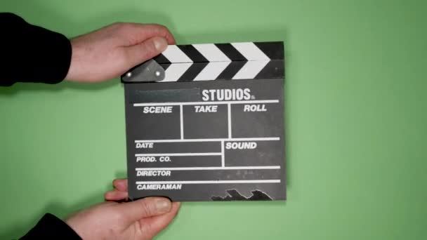 Hands hold black production clapper board on green screen - Footage, Video