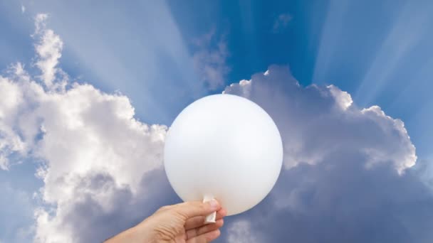 Weißer Ballon wird gegen einen wolkenverhangenen Himmel gesprengt - Filmmaterial, Video