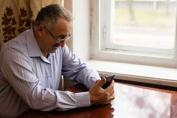 technologia, ludzie, koncepcja stylu życia i komunikacji - szczęśliwy senior wybierając numer telefonu i SMS-y na smartfonie w domu - Zdjęcie, obraz