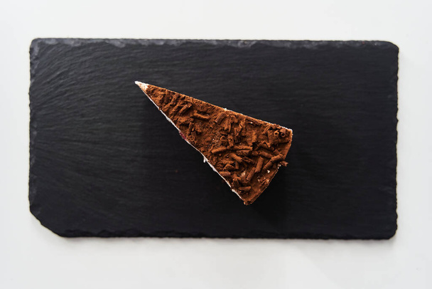 a slice of chocolate chip cake on a black tray. High quality photo - Fotografie, Obrázek