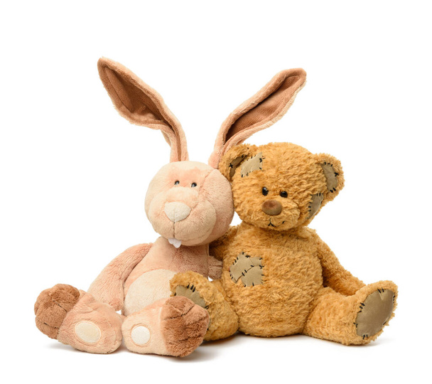 brązowy miś i słodki królik siedzieć na białym odizolowanym tle, zabawka z łatami - Zdjęcie, obraz