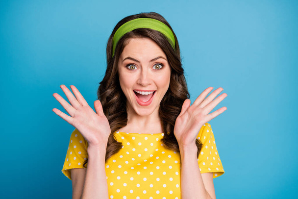 Photo of crazy astonished young lady shout loud raise hands wear polka-dot clothes isolated on blue color background - Foto, Imagem