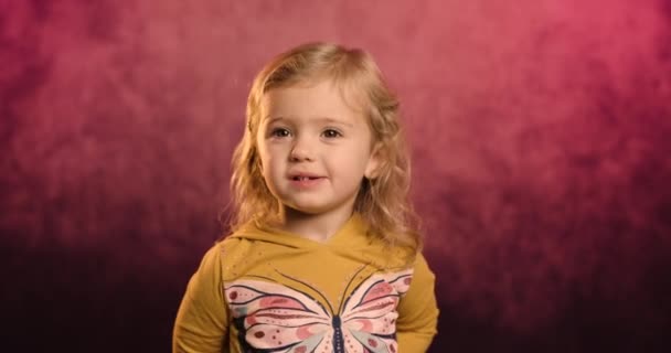 Portrét vzrušené holčičky čichající jahodovou izolaci na vídeňském pozadí ateliéru se směje vtipnému vtipu, radostné malé dítě se baví, dětský humor, koncepce zábavy - Záběry, video