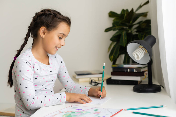 aranyos boldog kislány ír valamit a noteszébe - Fotó, kép