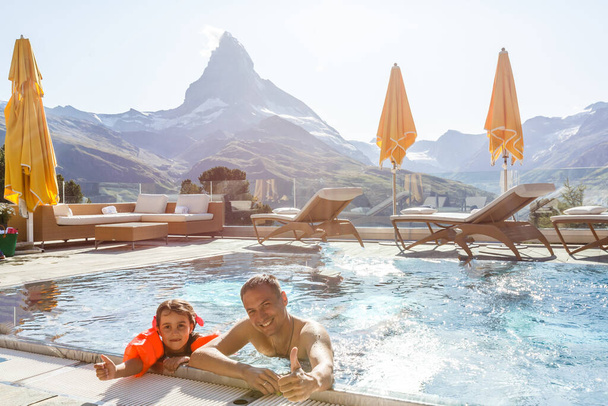 Famille En Piscine En Montagne. Belle scène en plein air dans les Alpes suisses, Suisse, Europe. - Photo, image