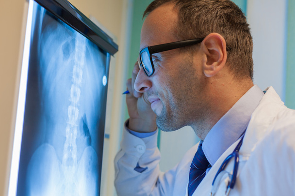 Доктор смотрит на рентгеновские снимки
 - Фото, изображение