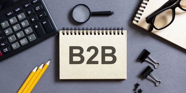 Блокнот з написами B2B на сірому фоні з офісними інструментами. бізнес
 - Фото, зображення