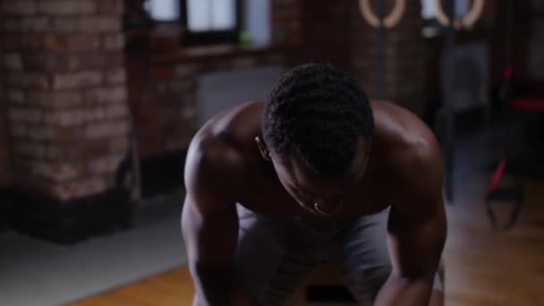 Африкано-американский красавец без рубашки тренируется в тренажерном зале - пьет воду и смотрит в камеру - Кадры, видео