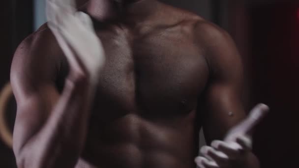 Trening siłowy - czarny sportowiec bez koszulki młody człowiek klaszczący w dłonie pokryte kredą - Materiał filmowy, wideo