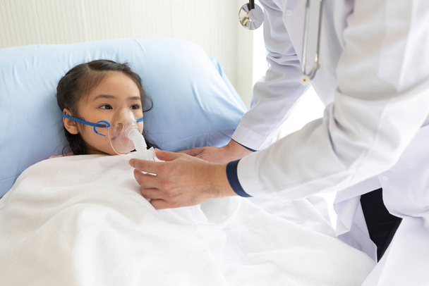 niña asiática paciente recibiendo ventilación artificial del médico en el hospital - Foto, Imagen