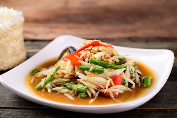 Thailändisches Essen (Som Tum), würziger grüner Papayasalat mit klebrigem Reis - Foto, Bild