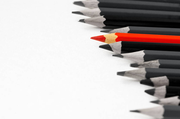 lápiz rojo de color entre los lápices grises y negros - Foto, imagen