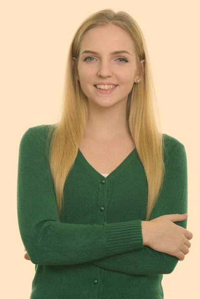 Studio shot de jeune adolescente heureuse souriant avec les bras croisés - Photo, image