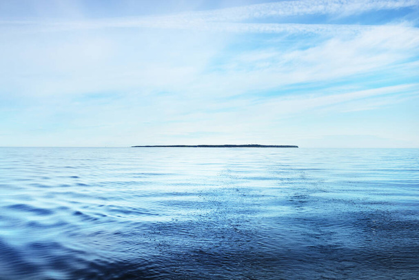 The calm water. A view of the Baltic sea on a sunny summer day. Blue water against the clear sky. Beautiful morning light - Photo, Image
