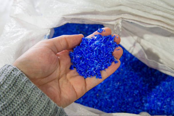Pellets plásticos azules del polímero en mano - Foto, Imagen