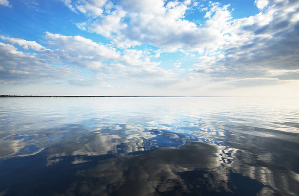 Kevätmerimaisema. Rauhallinen vesi. Kaunis värikäs auringonlasku Itämeren yllä. Valkoisia pilviä. Latvia - Valokuva, kuva