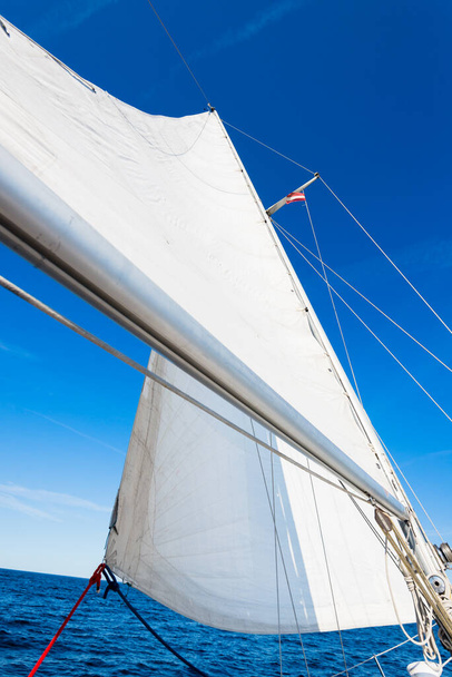 Lo sloop bianco ha truccato le vele dello yacht contro il cielo blu chiaro. Mar Baltico, Estonia - Foto, immagini