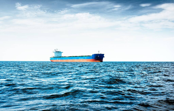Statek towarowy pod zachmurzonym błękitnym niebem, Morze Bałtyckie, Łotwa - Zdjęcie, obraz