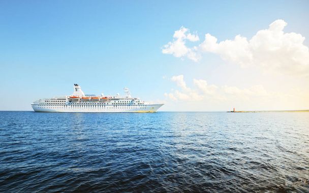Duży biały statek pasażerski na Morzu Bałtyckim, zbliżenie. Latarnia morska w tle. Zatoka Ryska, Łotwa - Zdjęcie, obraz