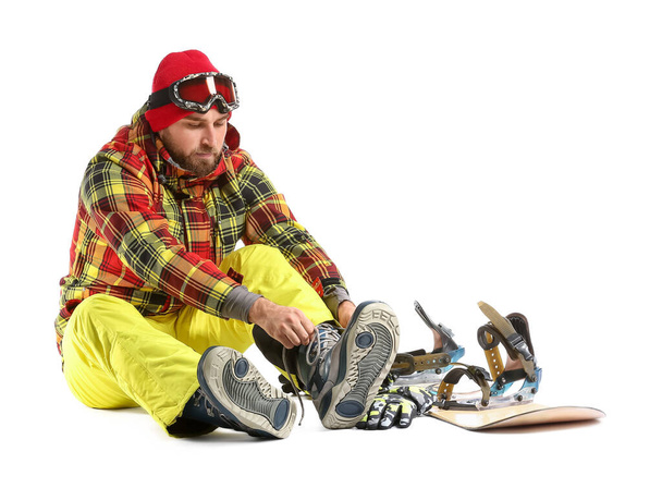 masculino snowboarder colocando em sapatos contra fundo branco - Foto, Imagem
